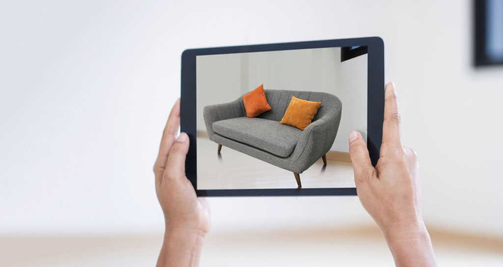 Nach oben gehaltenes Tablet mit Sofabild steht für Social-Media-Marketing im einrichtenden Handel