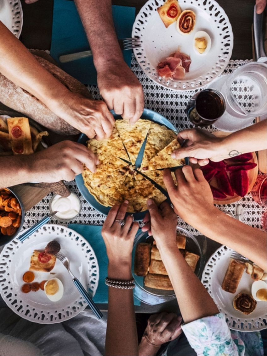 Blick von oben aufs Essen mit mehreren Händen symbolisiert Food Portal