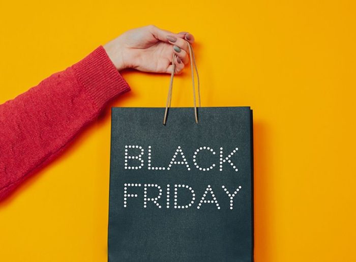 Hand, die Einkaufstüte mit Aufschrift Black Friday hält, symbolisiert Tipps und Planung zum Black Friday-Marketing