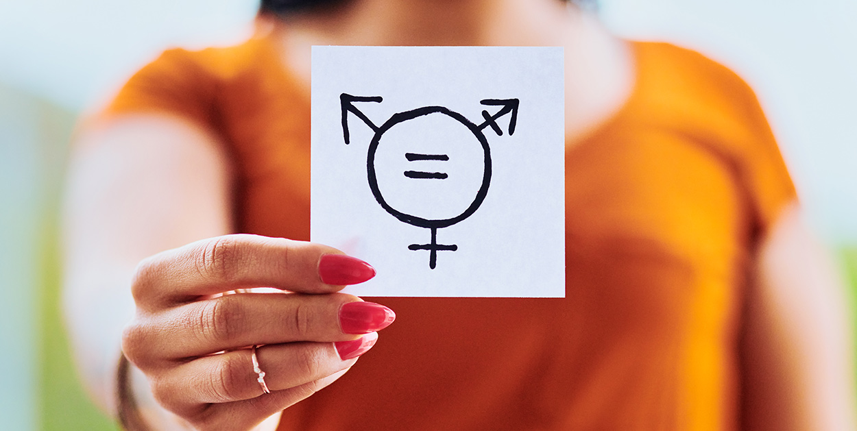 Frauenhand mit Zettel mit Gendersymbol symbolisiert Gendersprache in Unternehmen