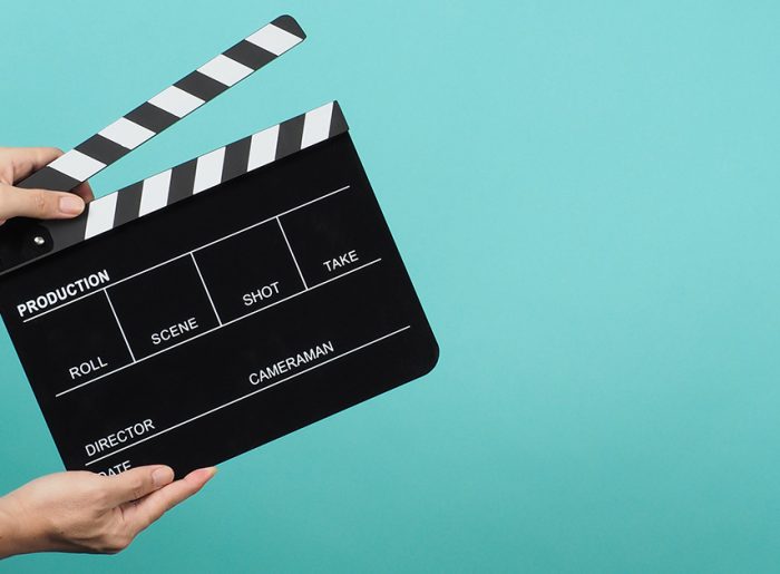Hände die eine Filmklappe halten, symbolisieren Video-Marketing