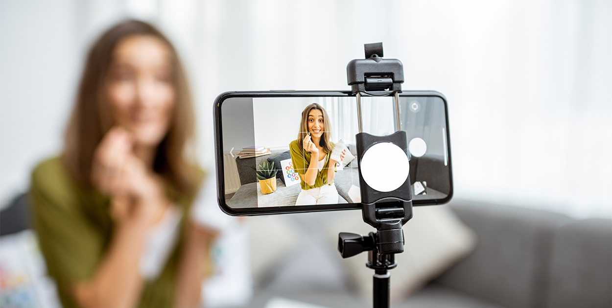 Junge Frau, die ein Selfie von sich macht, steht für Influencer-Marketing