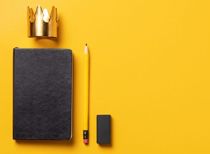 Notizbuch, Stift, Radiergummi und Krone stehen für Tipps zur erfolgreichen Jahresplanung für Unternehmen