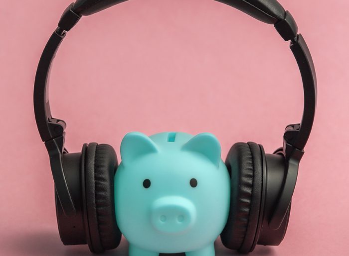 Sparschwein mit aufgesetzten Kopfhörern symbolisiert Kosten von Radiowerbung