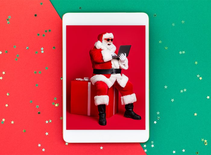Weihnachtsmann mit Notebook symbolisiert die Top 5 der Weihnachts-Werbespots 2022