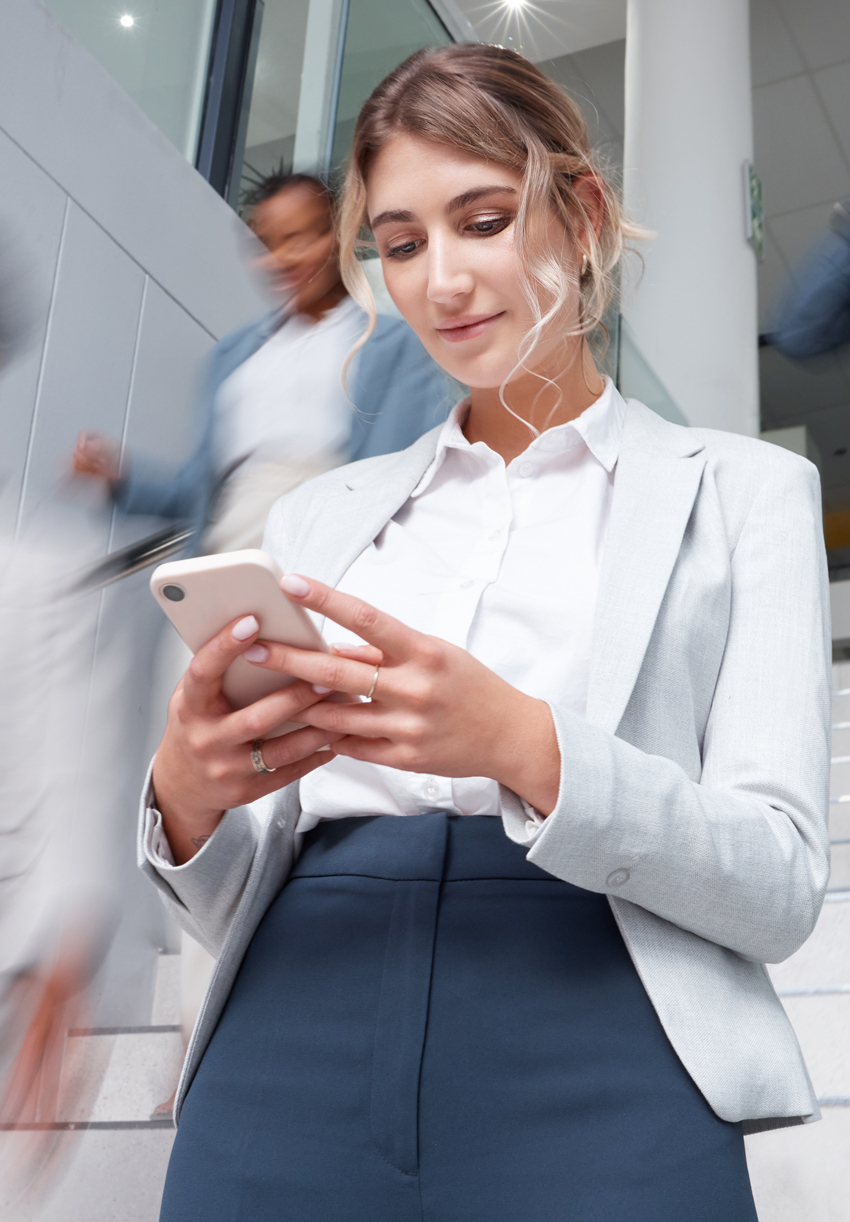 Beschäftigte Frau am Handy symbolisiert erfolgreiches B2B-Marketing mit der FUNKE MediaSales